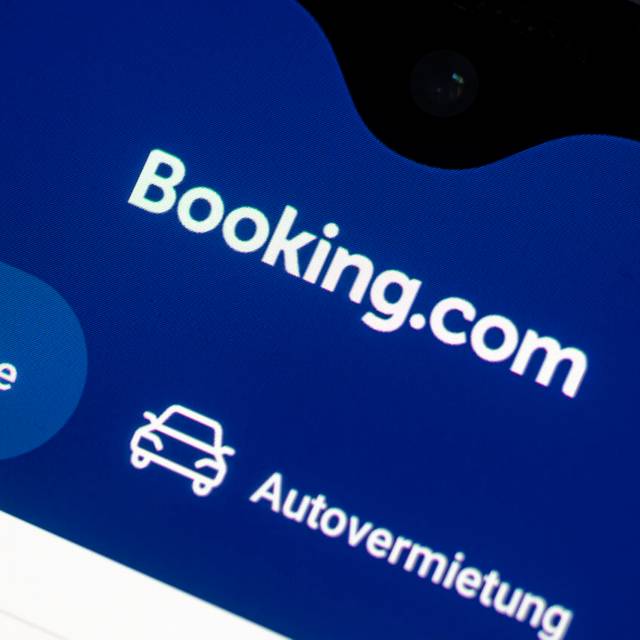 Auf einem Smartphone ist die App des Reiseportals Booking.com zu sehen.