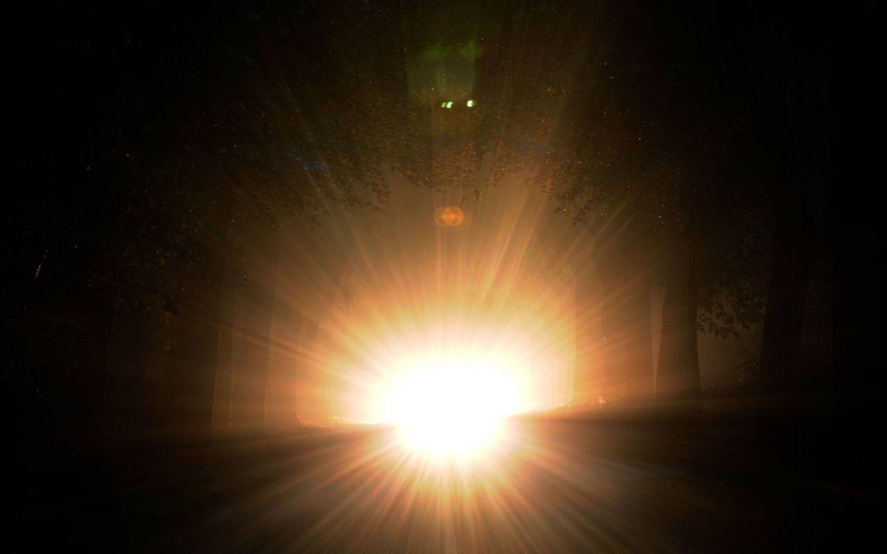 Auto mit Aufblendlicht bei Nacht