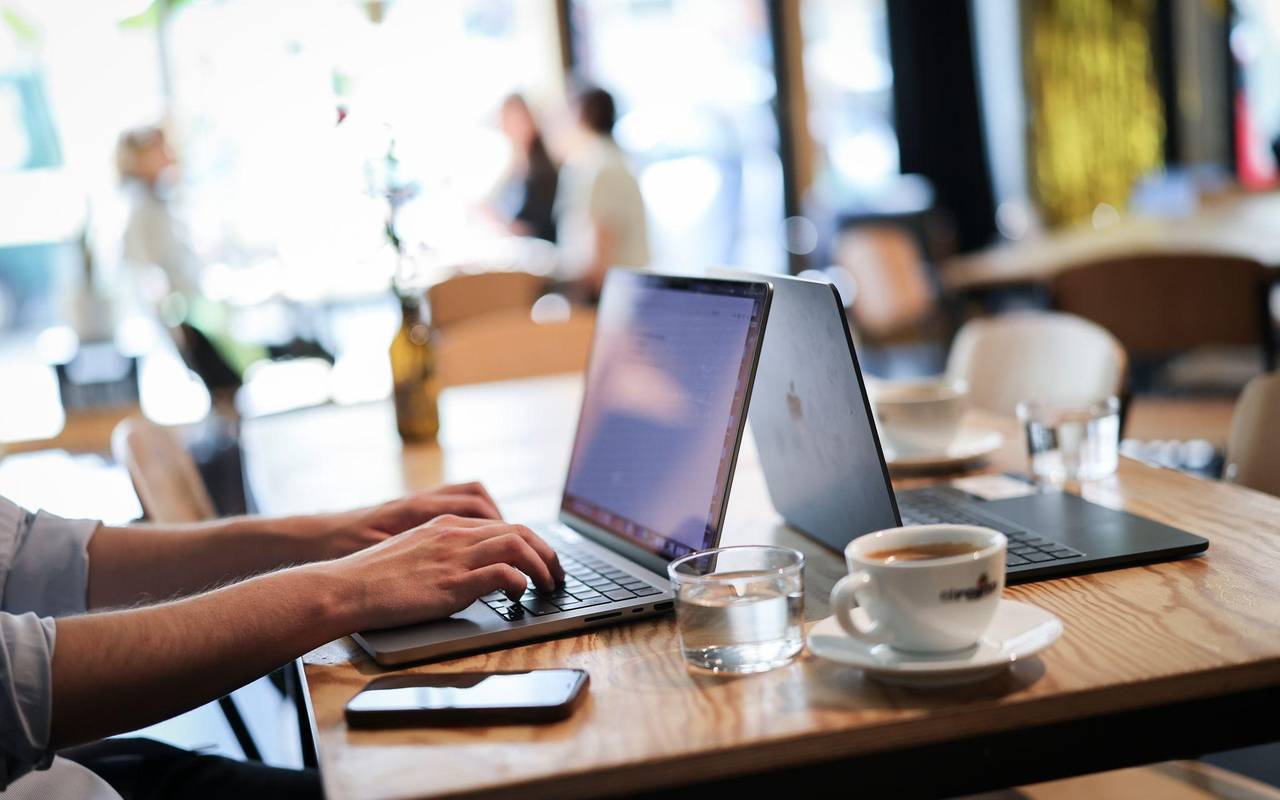 Ein Mensch arbeitet an seinem Computer in einem Café