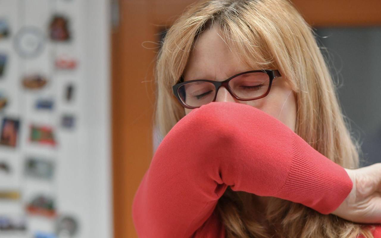 Eine Frau hustet in ihre Armbeuge