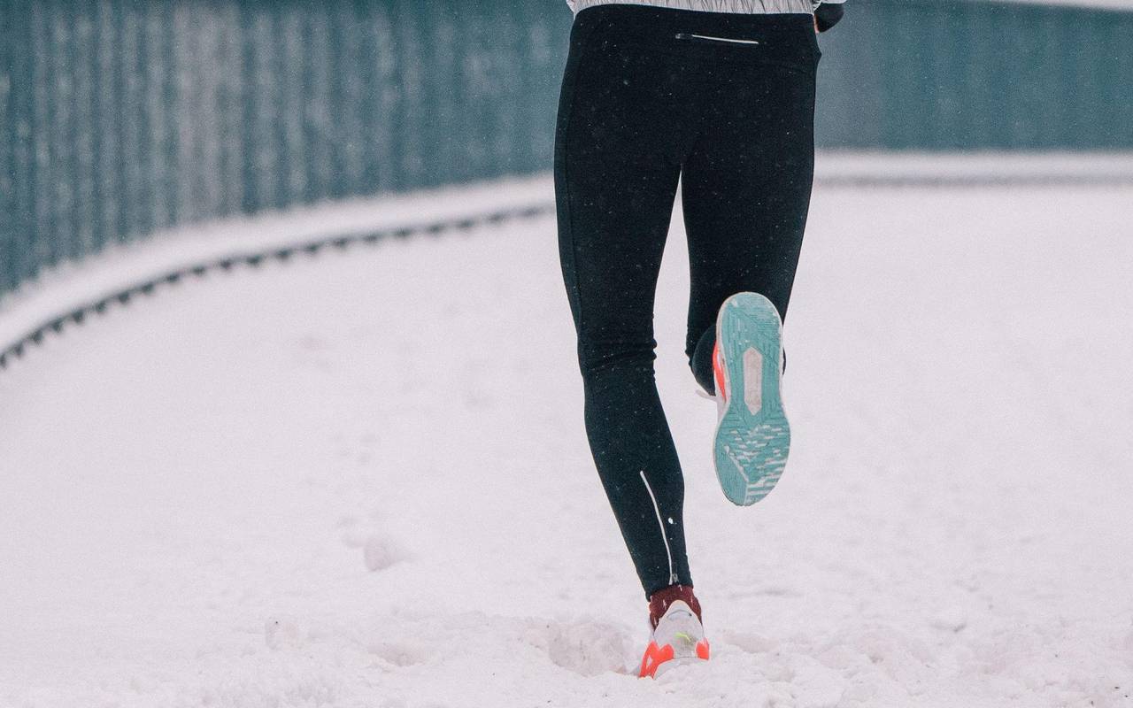 Eine Joggerin läuft durch Schnee