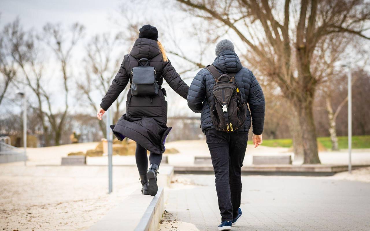 Spaziergänger durchqueren bei trübem Wetter einen Park