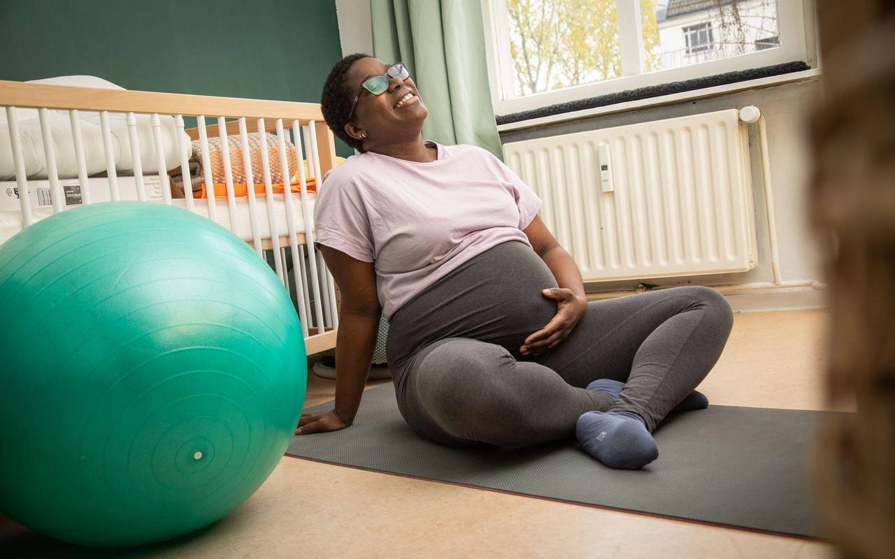 Eine schwangere Frau auf einer Yogamatte