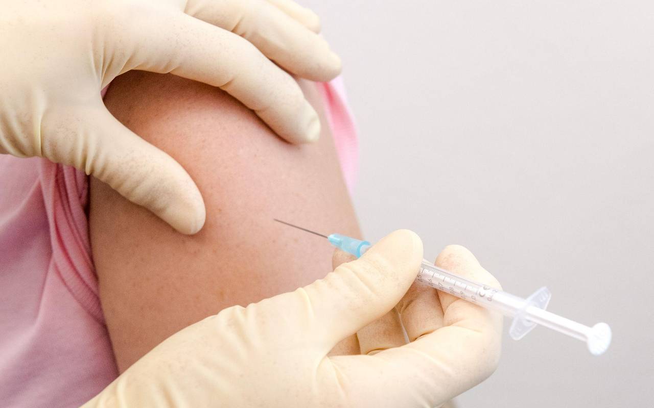 Eine Frau wird in den Oberarm geimpft