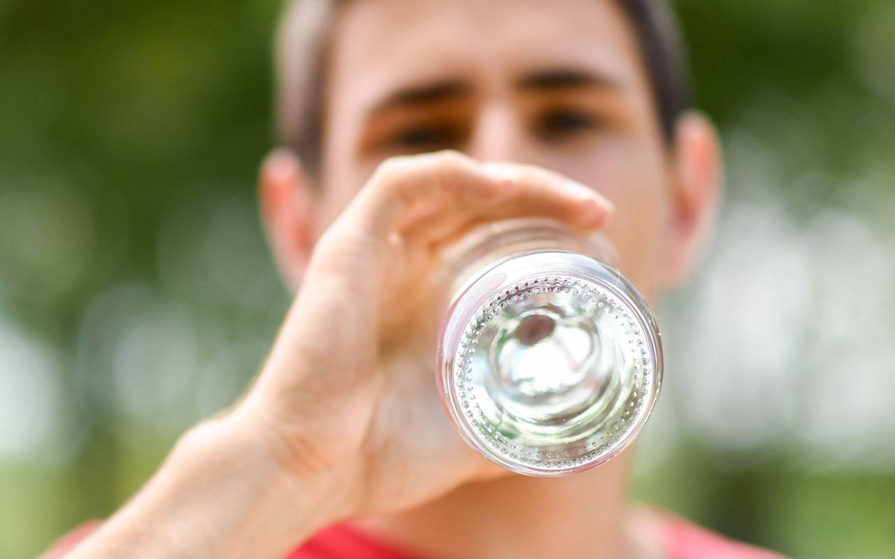 Mann trinkt aus einer Flasche Mineralwasser
