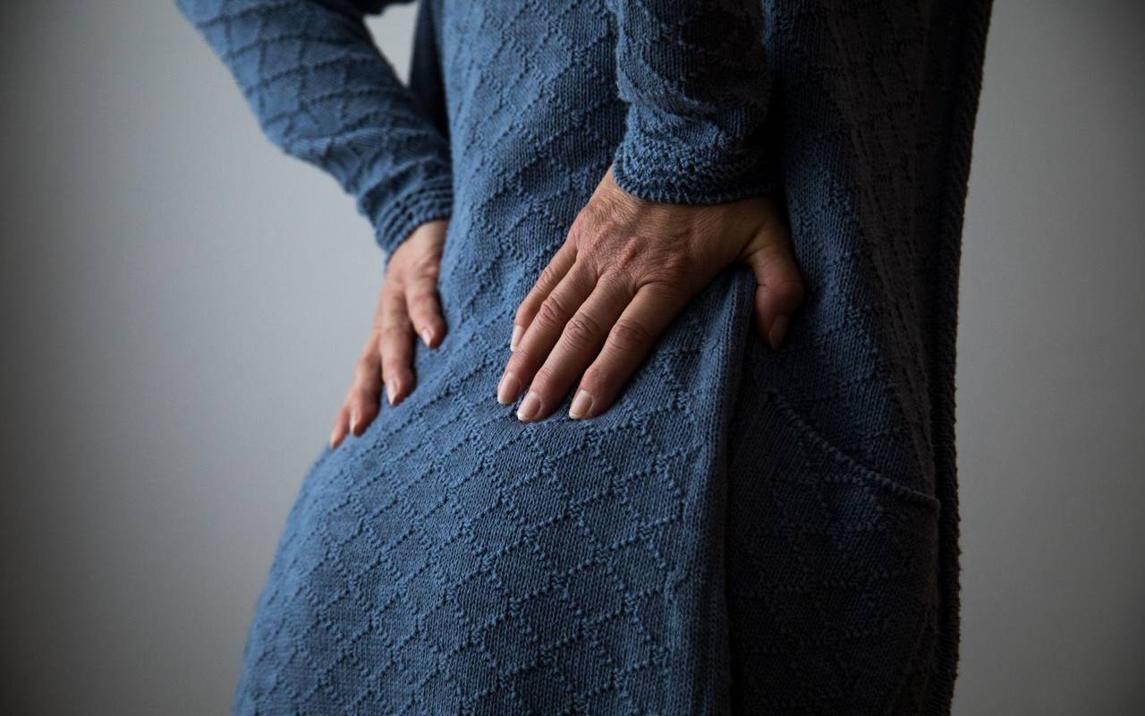 Frau hält sich den schmerzenden Rücken