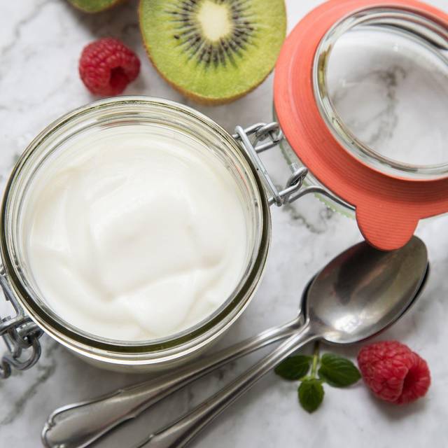 Einmachglas mit einem Milchprodukt steht auf einem Tisch