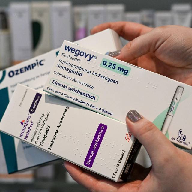 Eine Frau hält Abnehmspritzen verschiedener Marken in den Händen