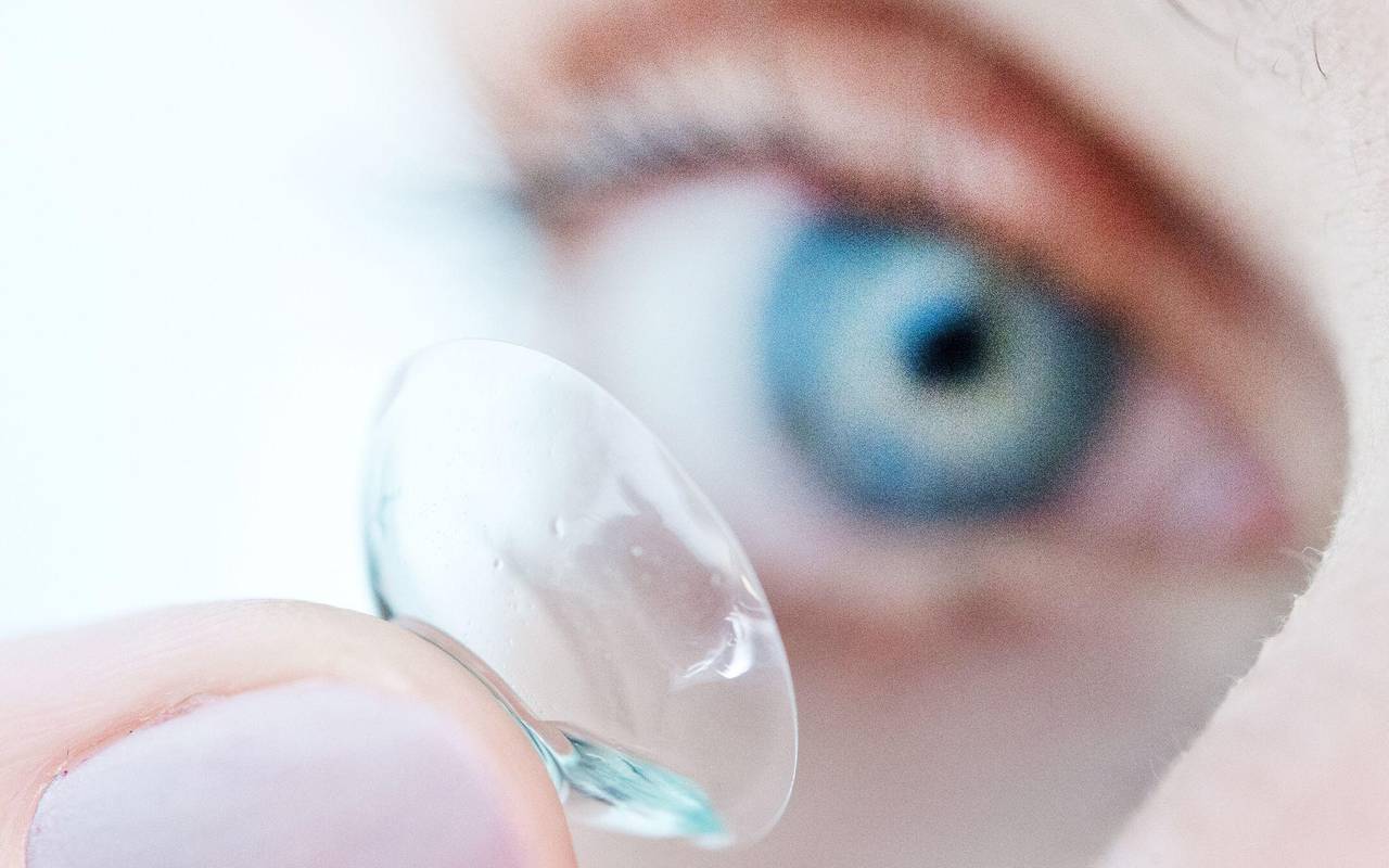 Eine Person hält eine Kontaktlinse auf dem Finger