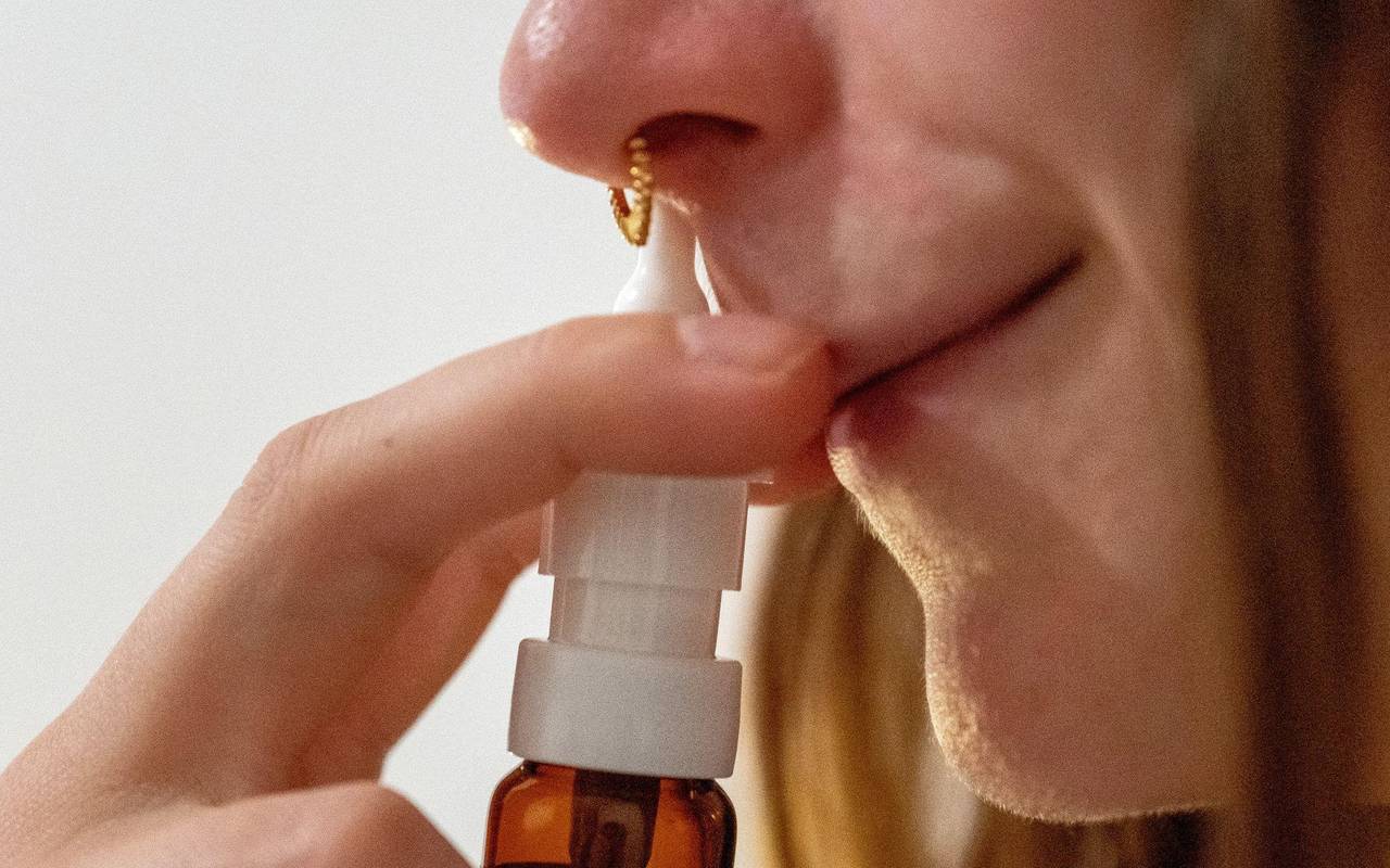 Eine Frau verwendet ein Nasenspray