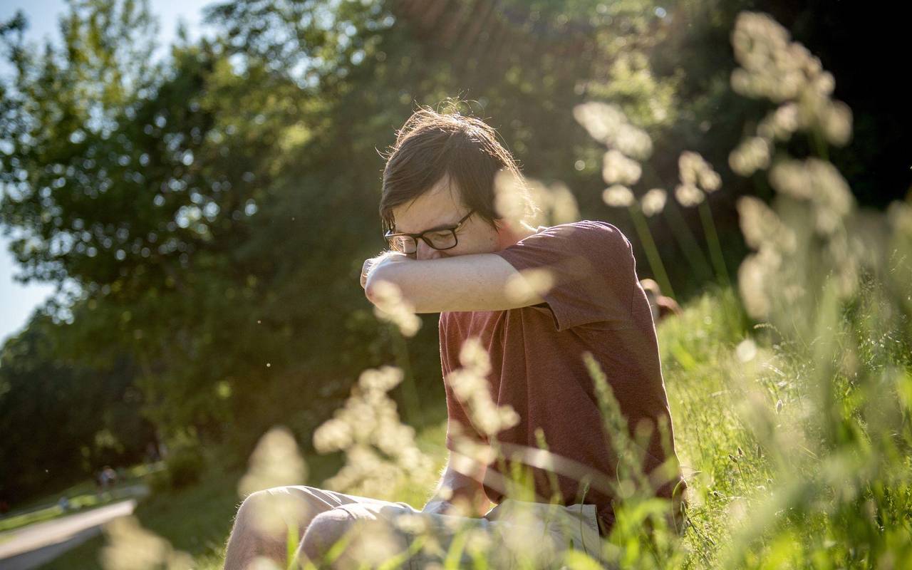 Mann in einem Park niest