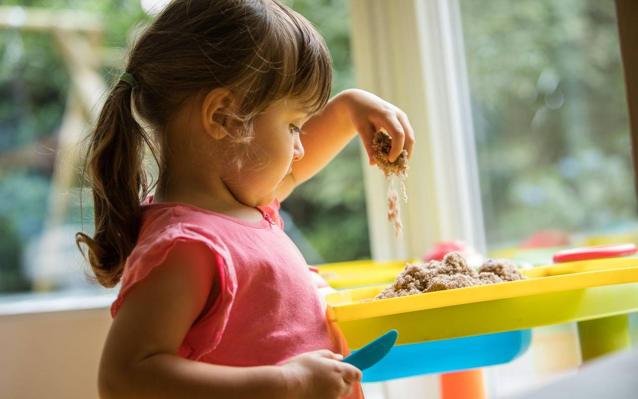 Ein Mädchen soielt mit Knetsand
