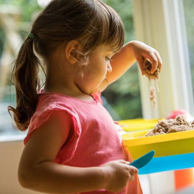 Ein Mädchen soielt mit Knetsand