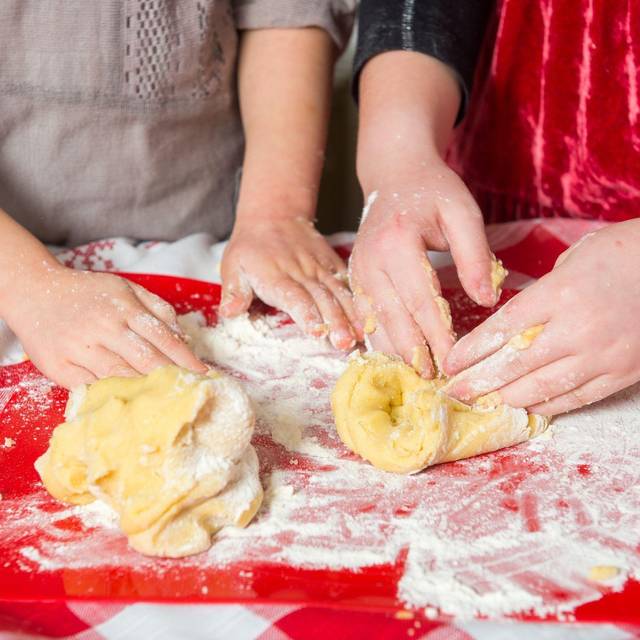 Zwei Mädchen kneten rohen Teig