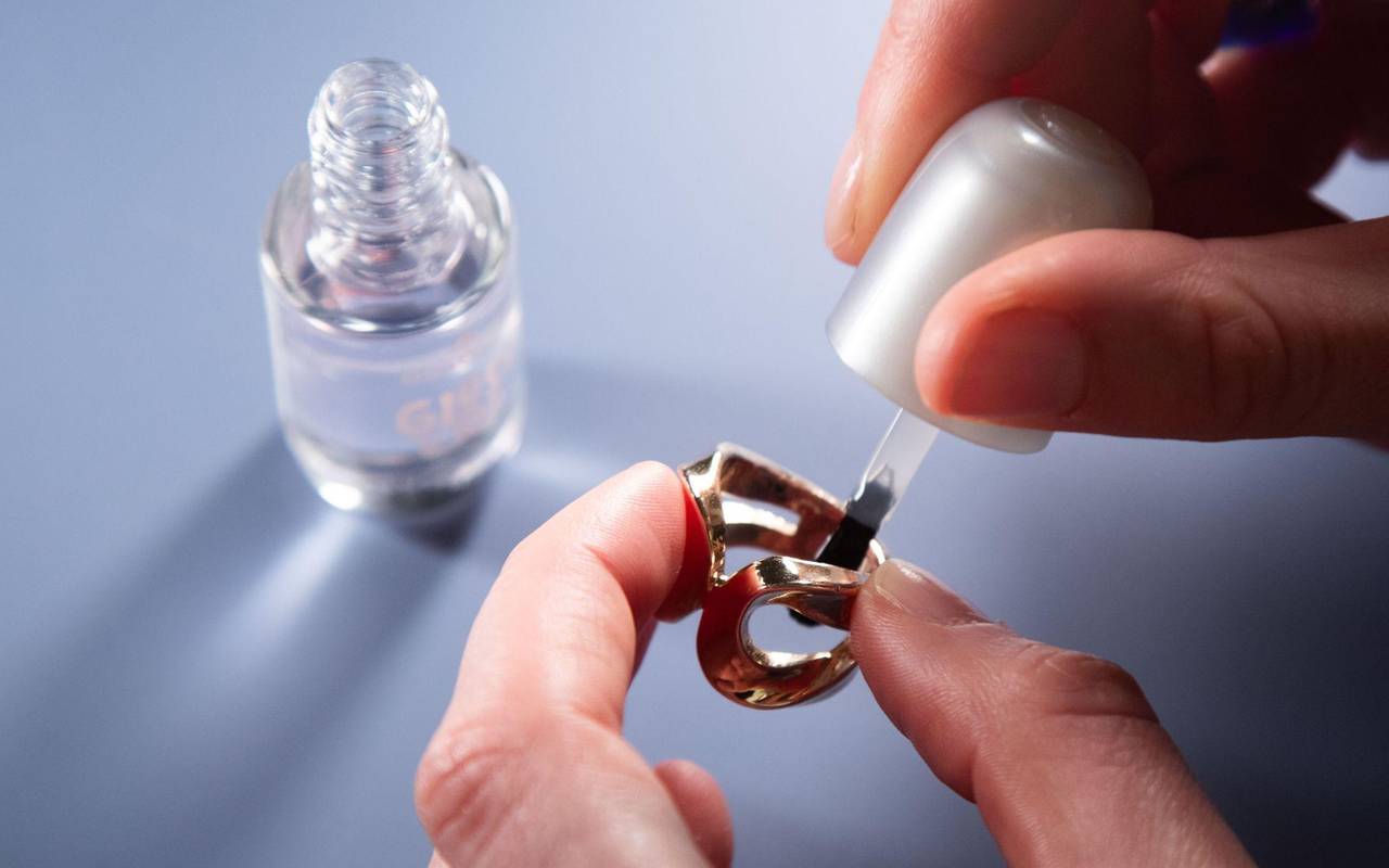 Ein Ring wird innen mit klarem Nagellack eingepinselt