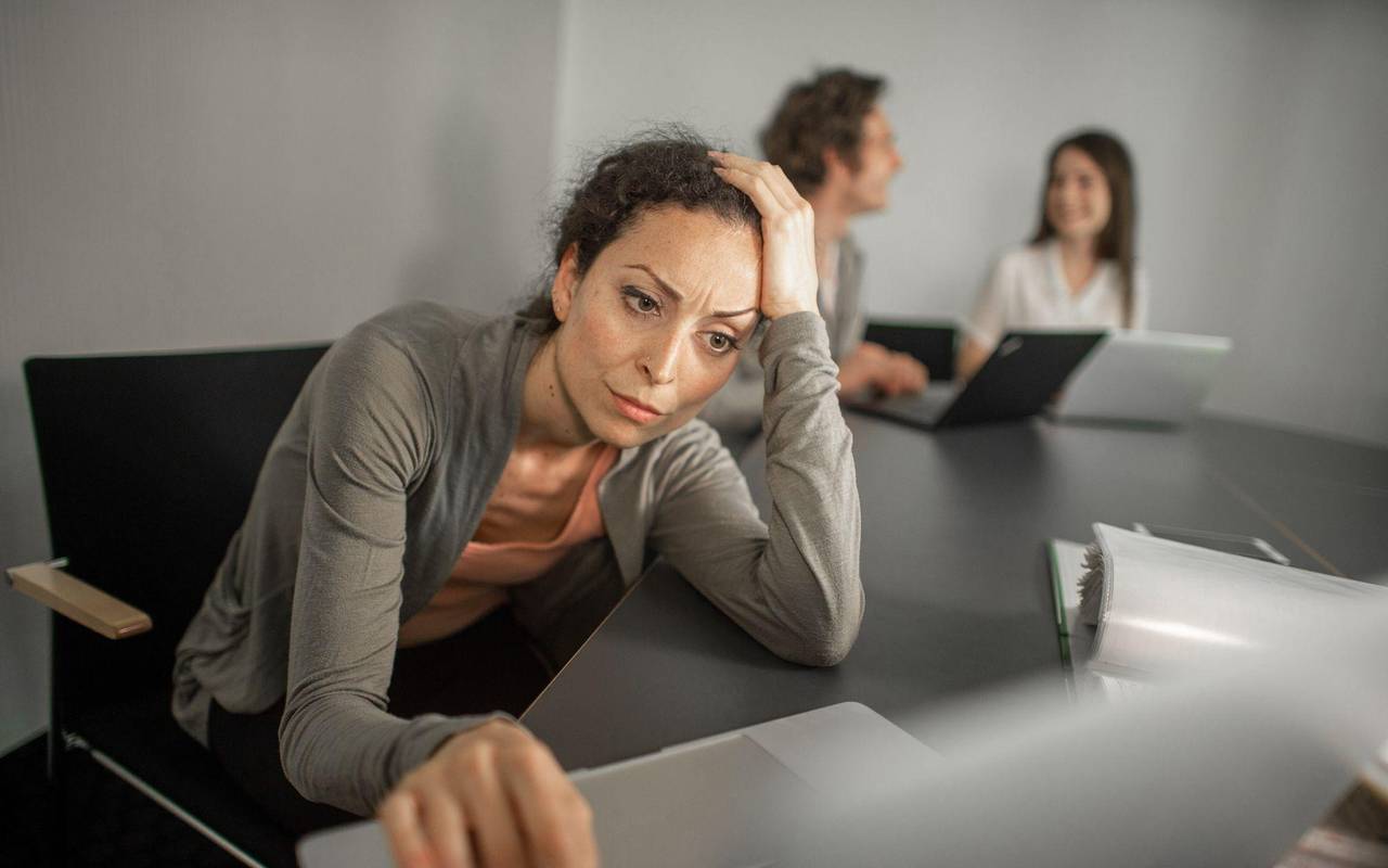 Frau sitzt grübelnd vor ihrem Laptop im Büro