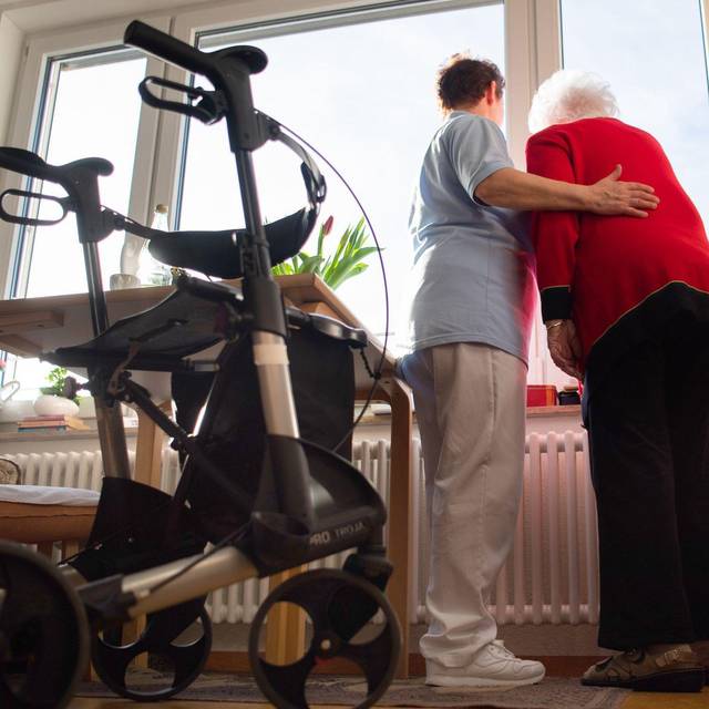 Eine Pflegerin unterstützt eine Heimbewohnerin