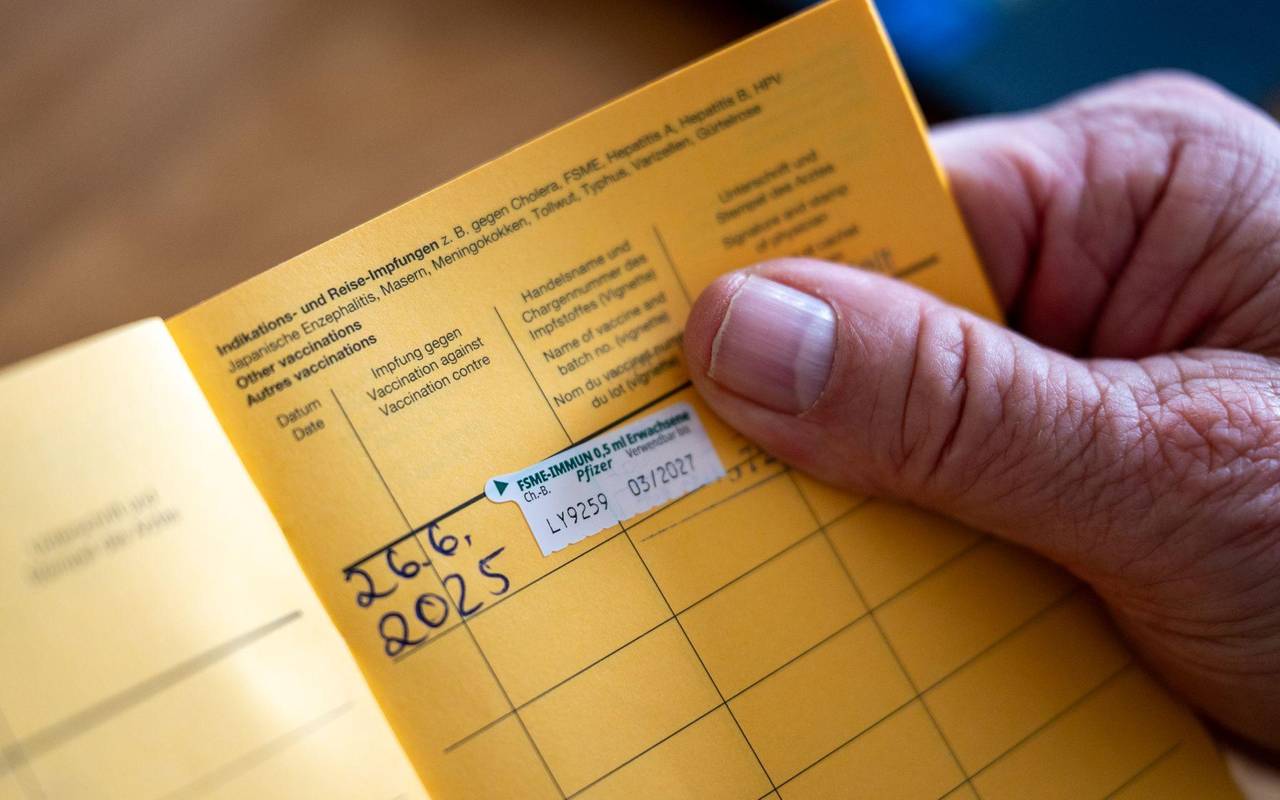 Ein Mann hält einen Impfpass in der Hand