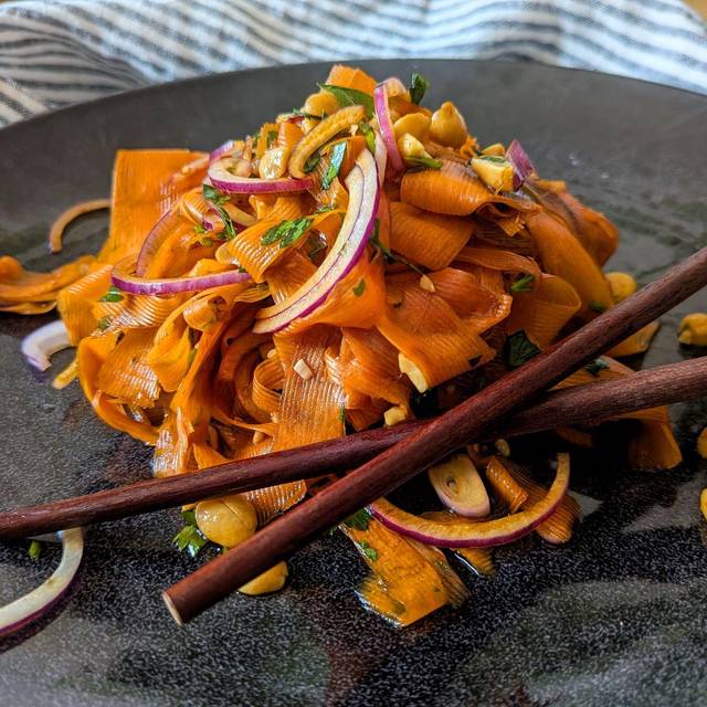 Ein Teller mit Karottensalat im Asia-Style steht auf dem Tisch