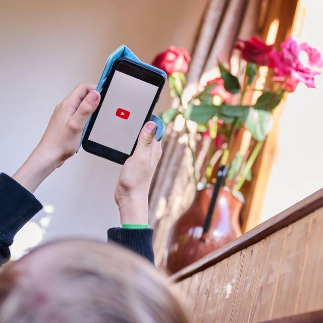 Junge öffnet auf seinem Smartphone die App von YouTube
