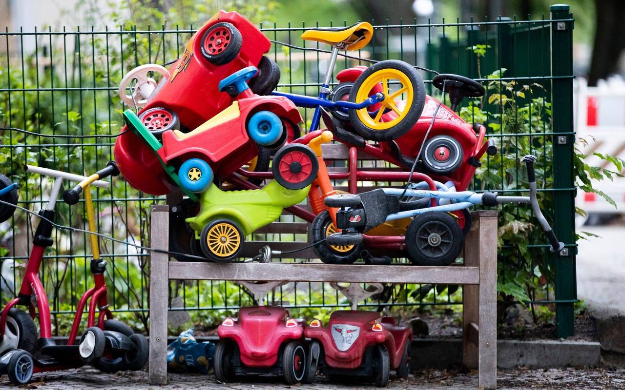 Spielautos für Kinder stehen vor einer Kita