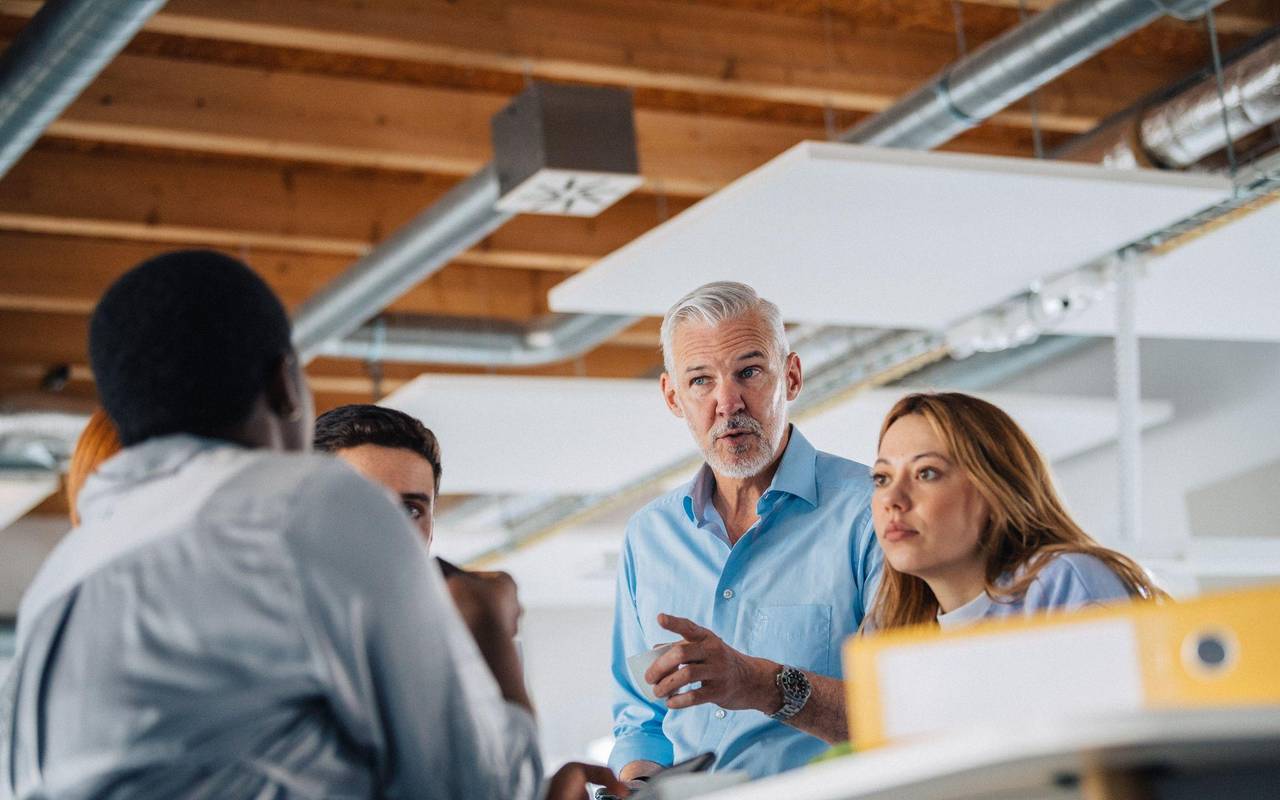 Eine Gruppe Kolleginnen und Kollegen an einem Stehtisch