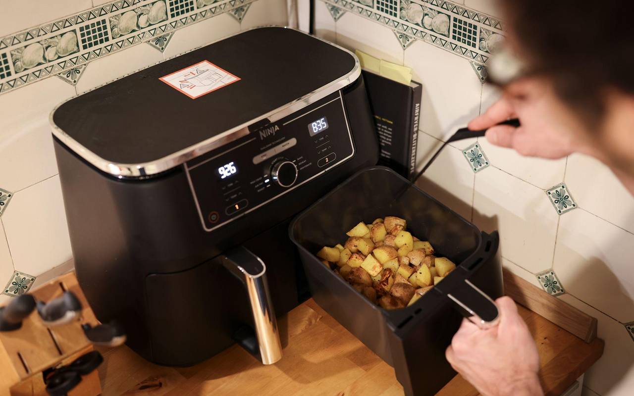 Mann kocht mit einem Airfryer