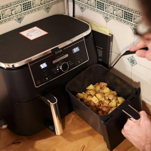 Mann kocht mit einem Airfryer