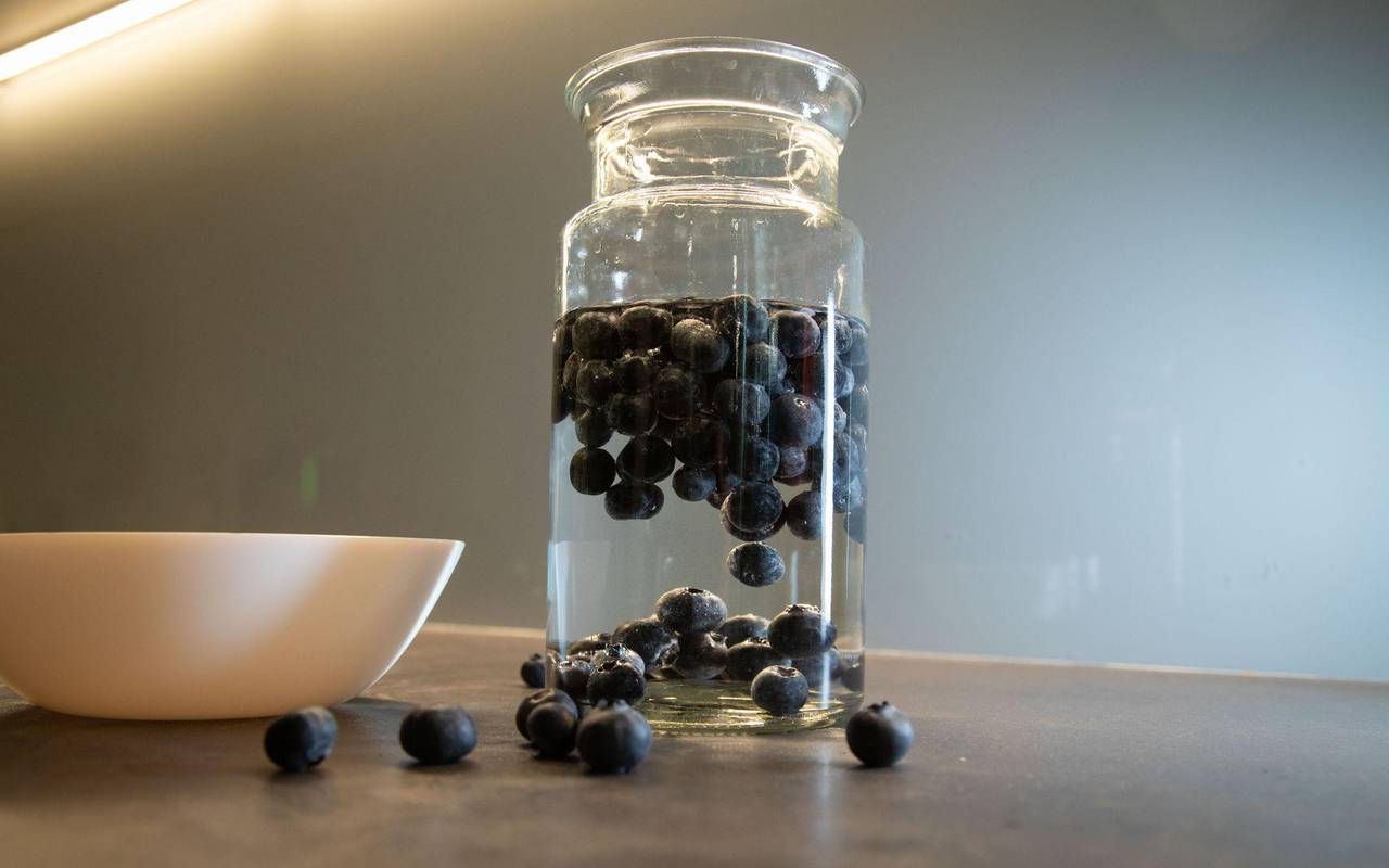Blaubeeren schwimmen in einem Glas mit Wasser
