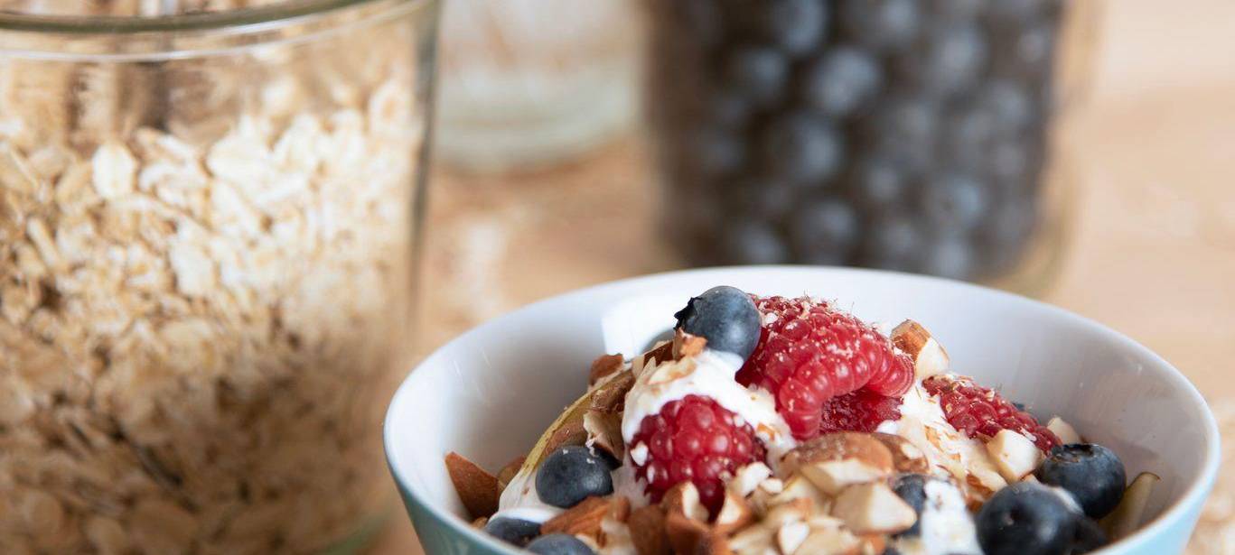 Müsli mit Haferflocken, Nüssen, Himbeeren und Blaubeeren