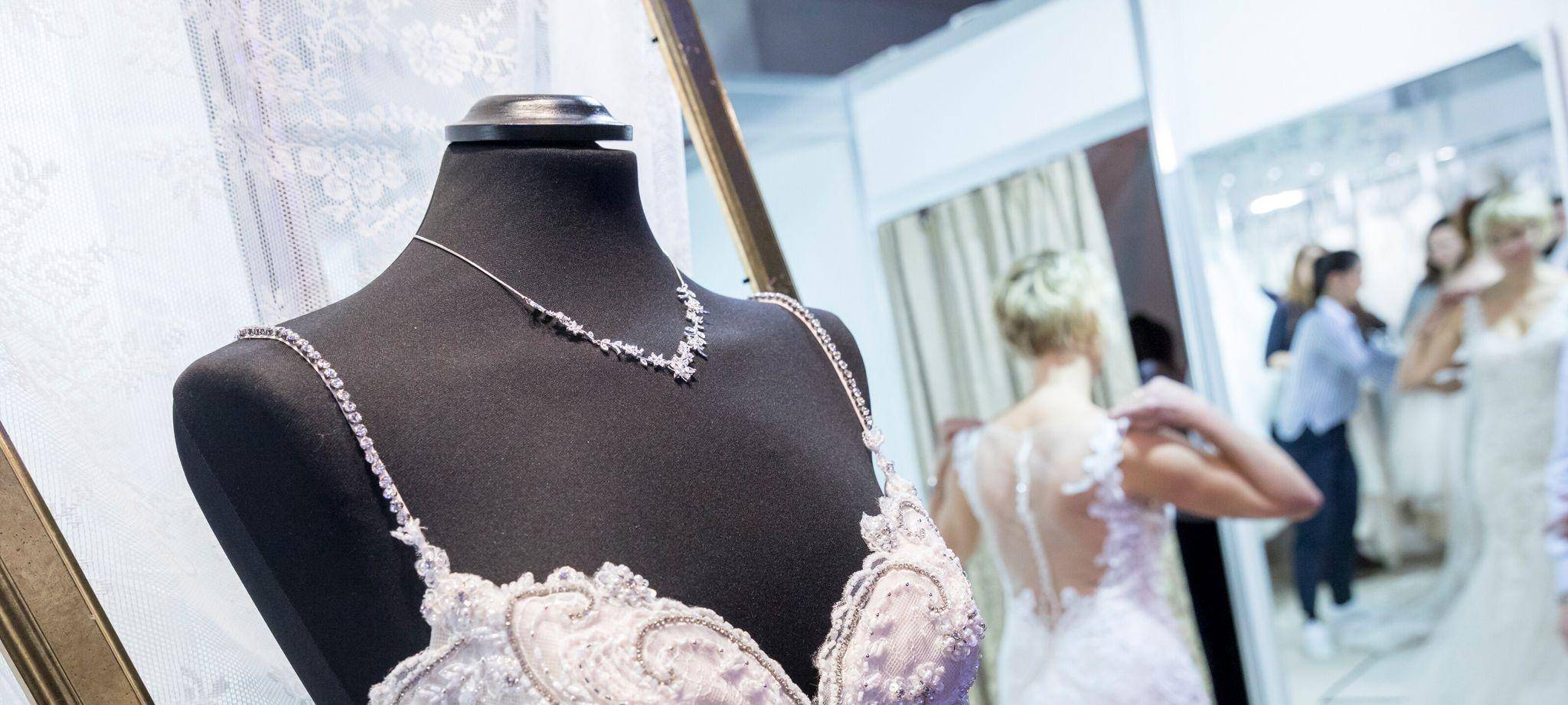 Messebesucherin probiert ein Hochzeitskleid an