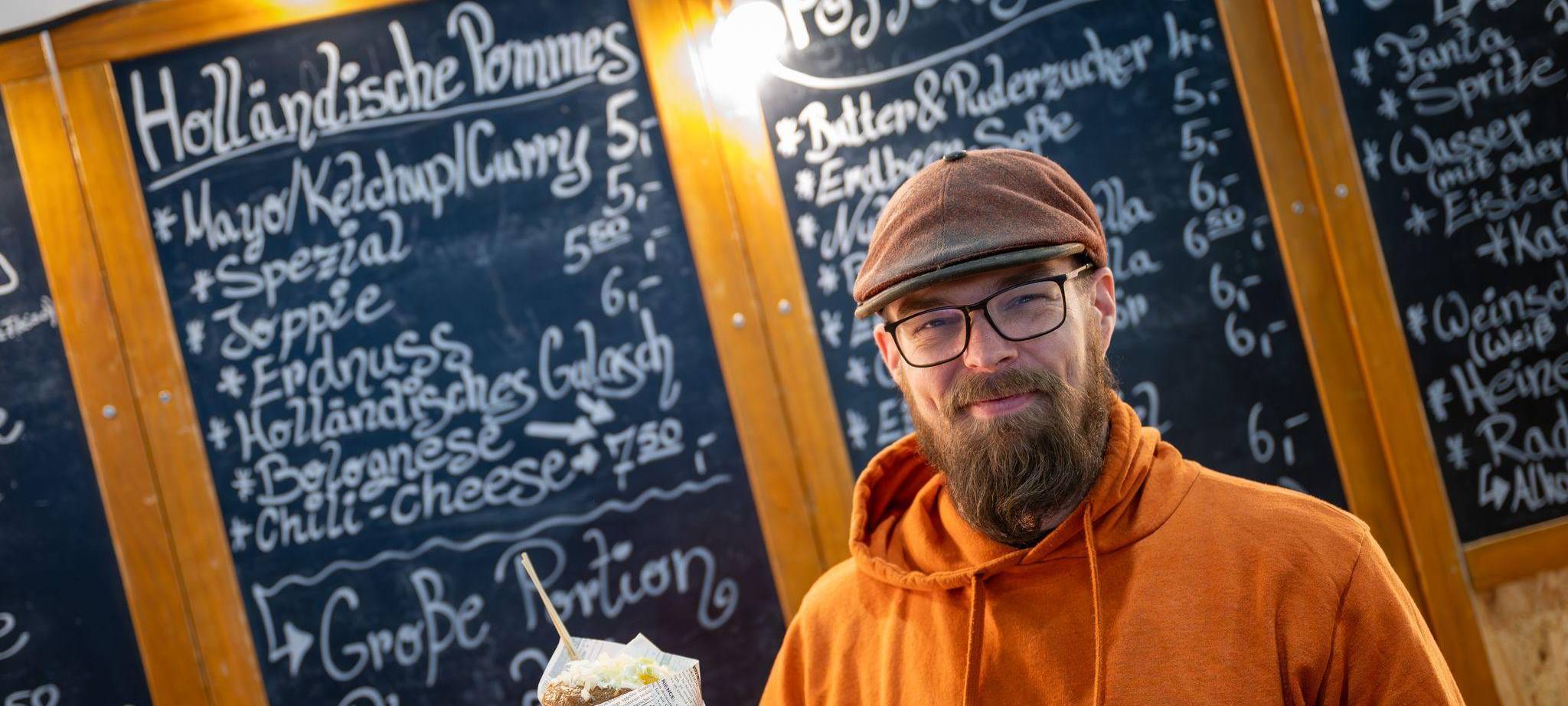 Nick Slagter hält eine Tüte Pommes in der Hand