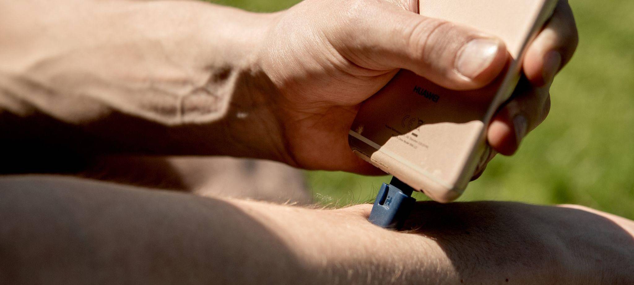 Ein Mann verwendet einen Stichheiler als Smartphoneaufsatz