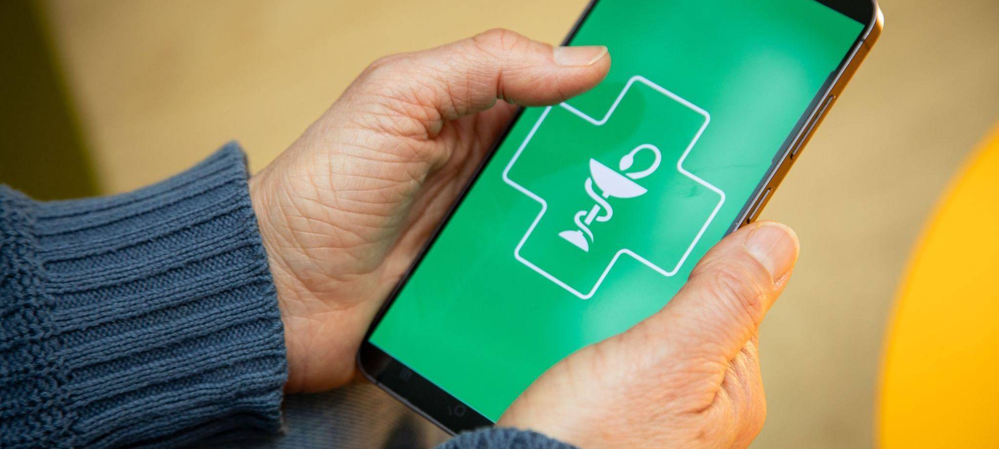 Frau hält ein Smartphone mit einer Gesundheits-App in den Händen