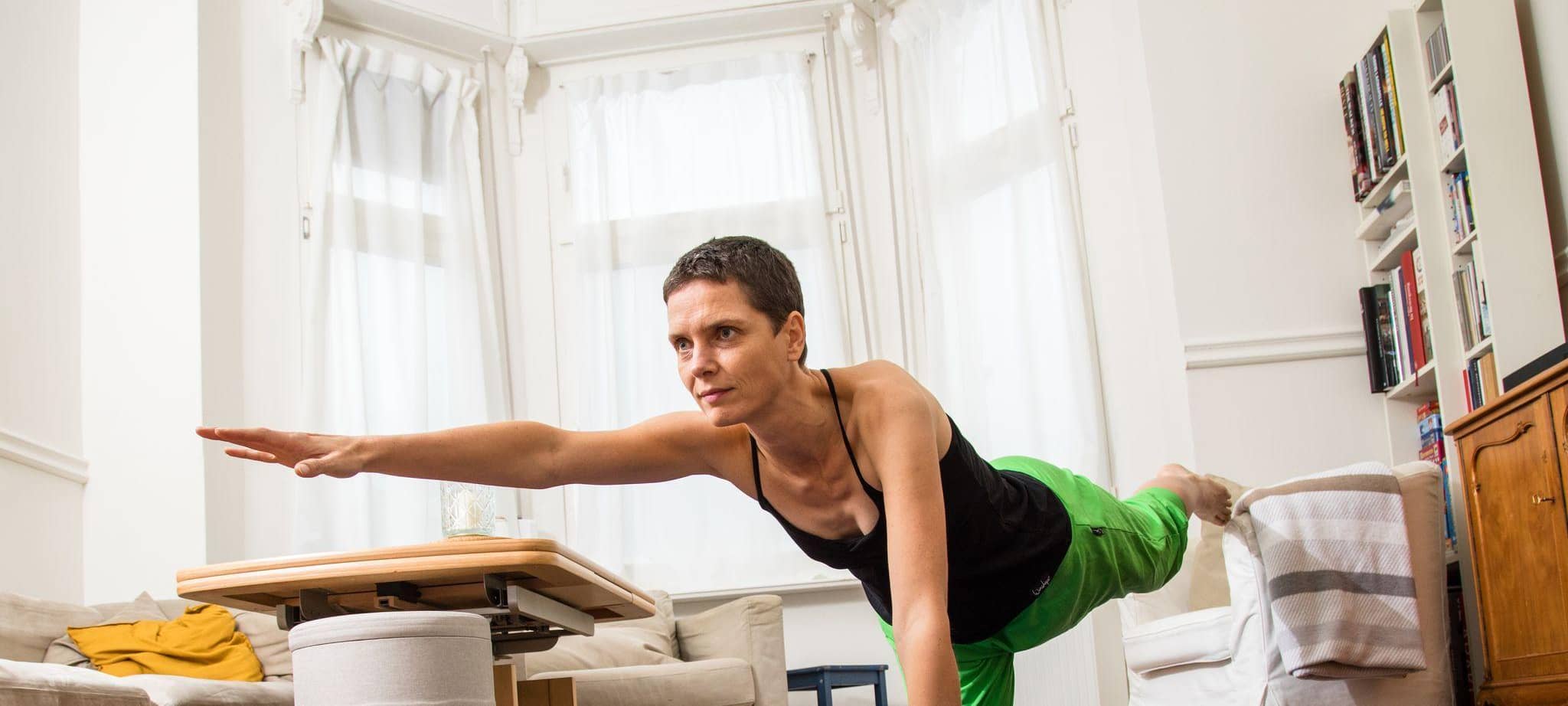Eine Frau macht Yoga Übungen im Wohnzimmer
